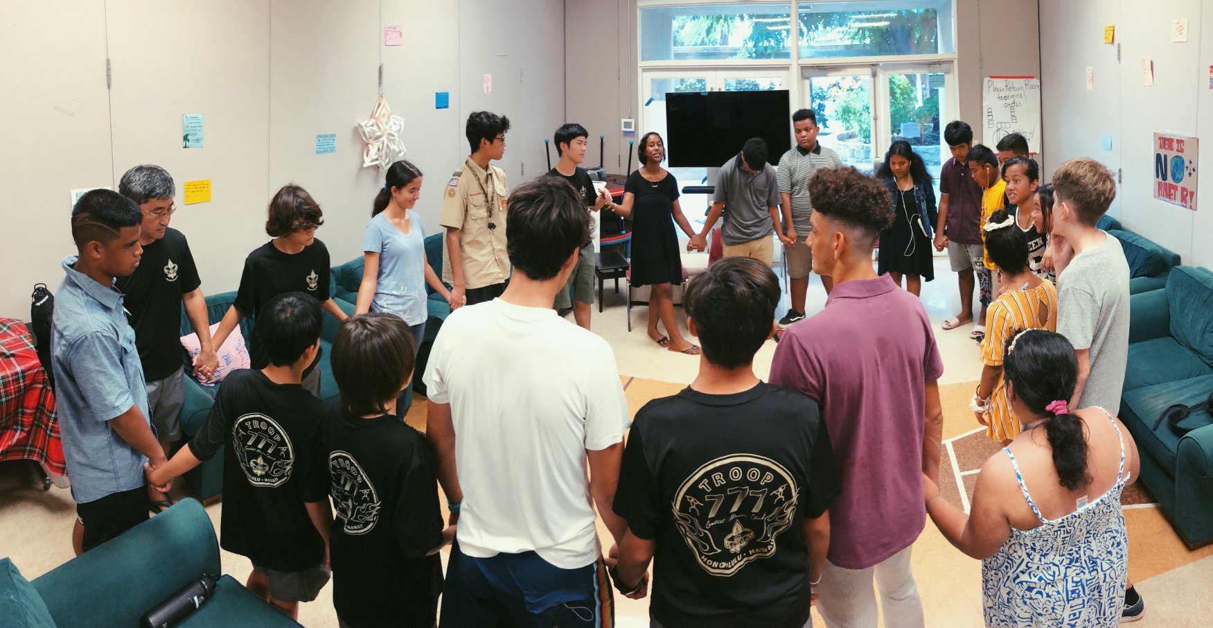 youth standing in a circle, hands joined