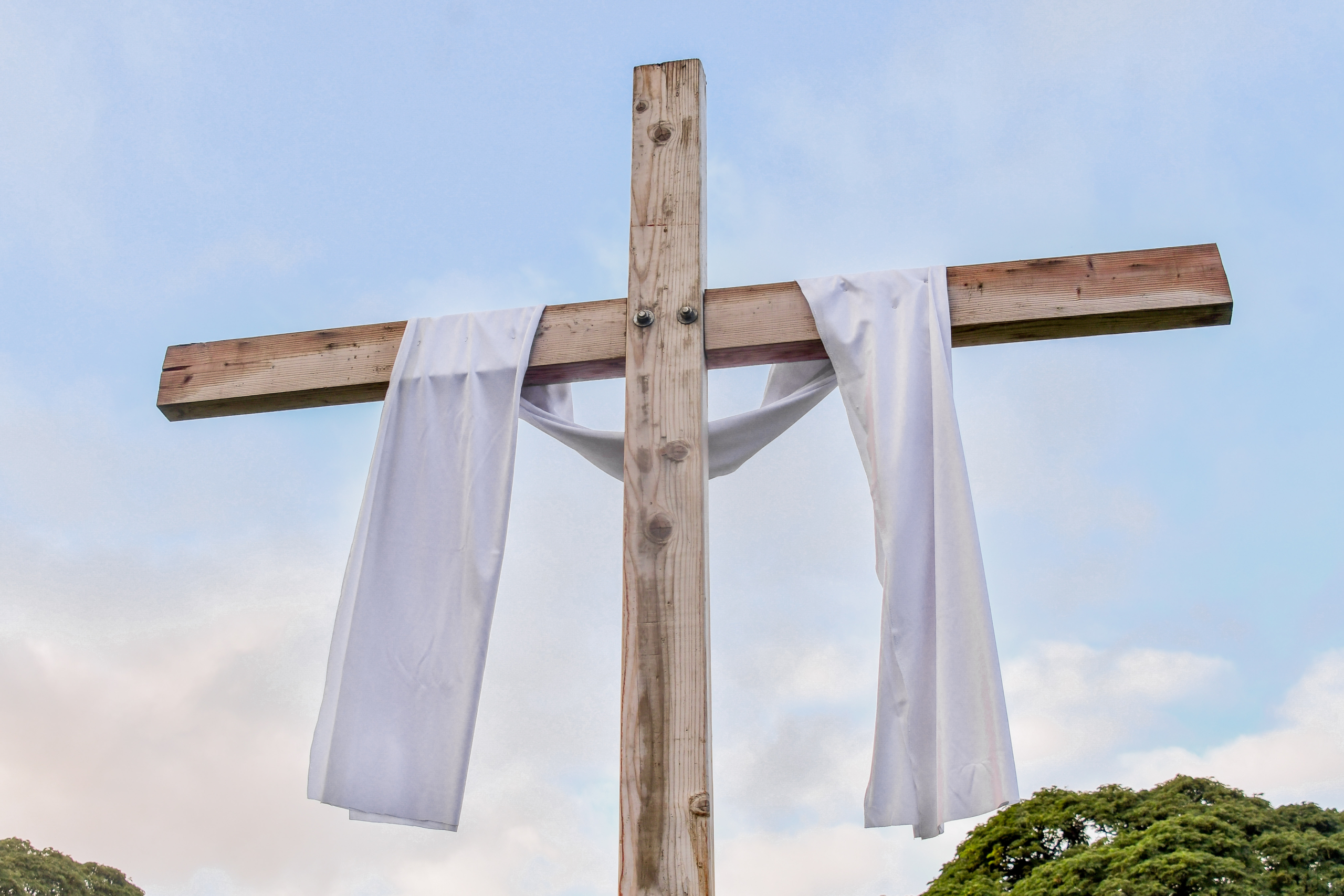 wooden cross with white fabric draped across for Easter