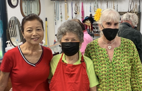three women Joan Carol Georgia volunteer in the thrift shop smile for photo