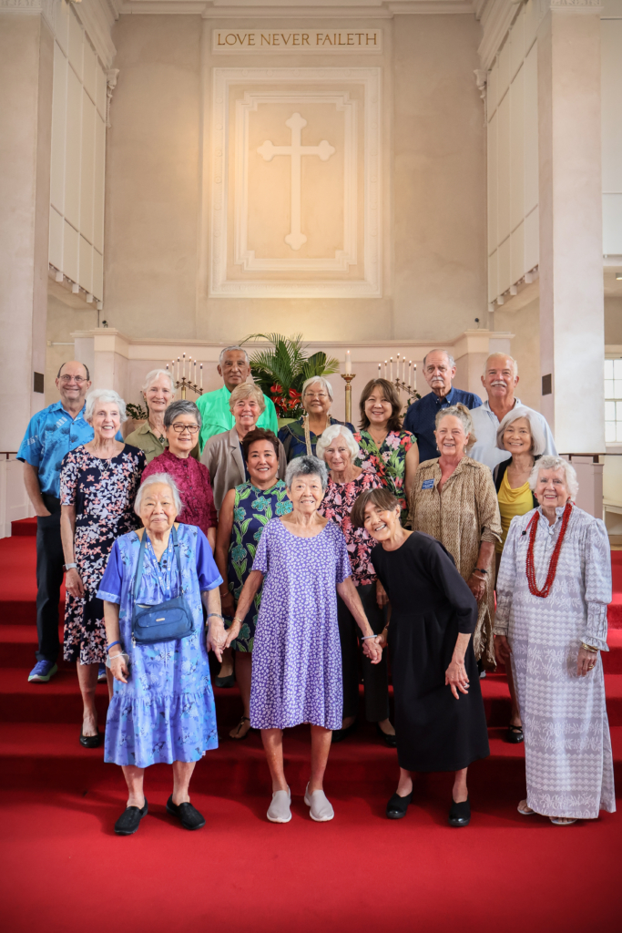 18 members standing in central union sanctuary beneath love never faileth cross